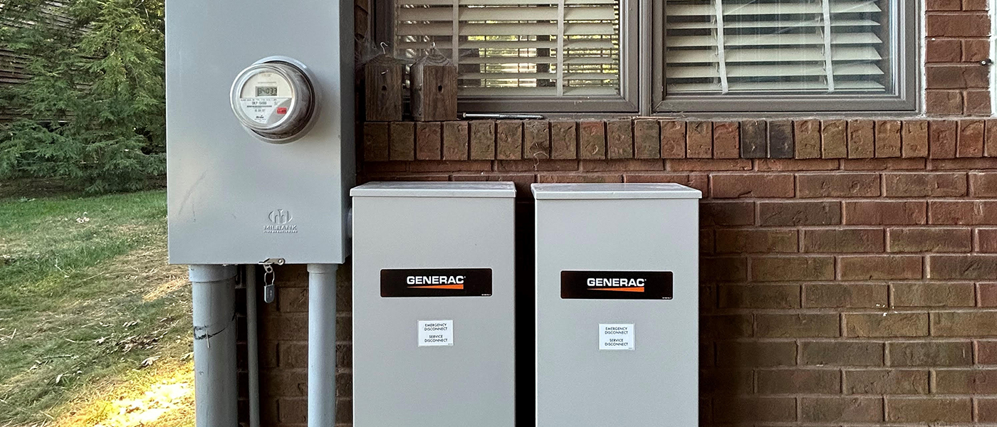 Residential Generac emergency disconnect boxes and electric meter installed on brick home exterior, professional generator electrical panel and utility connection services